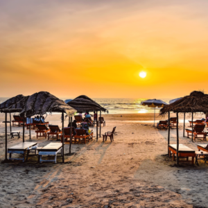 A serene sunset over Ashwem Beach in Goa, India, with vibrant hues reflecting on the tranquil waters